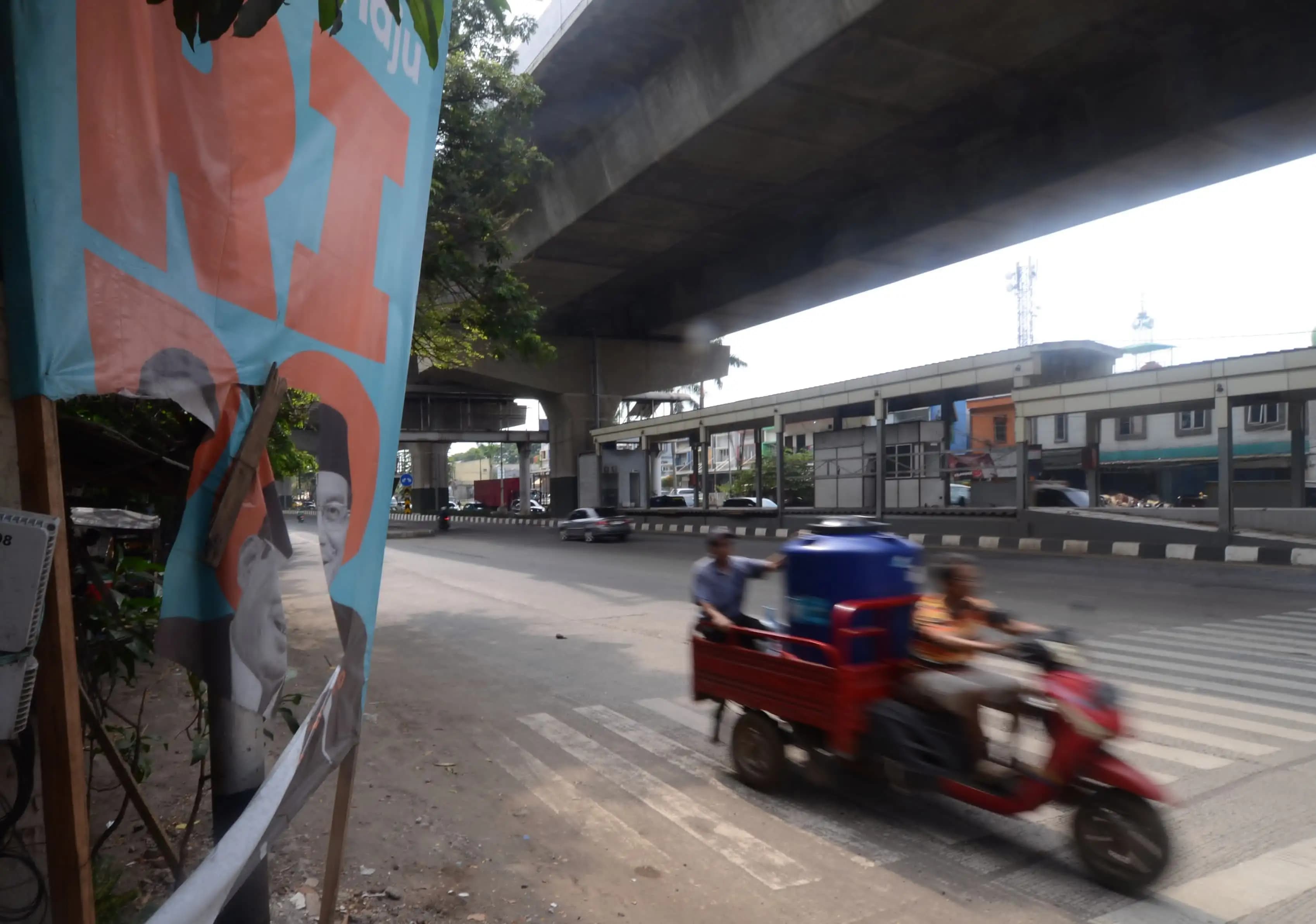 Warga melintasi baliho calon gubernur dan wakil gubernur Ridwan Kamil-Suswono yang mengalami aksi vandalisme (Foto: Dok MI/Donavita)