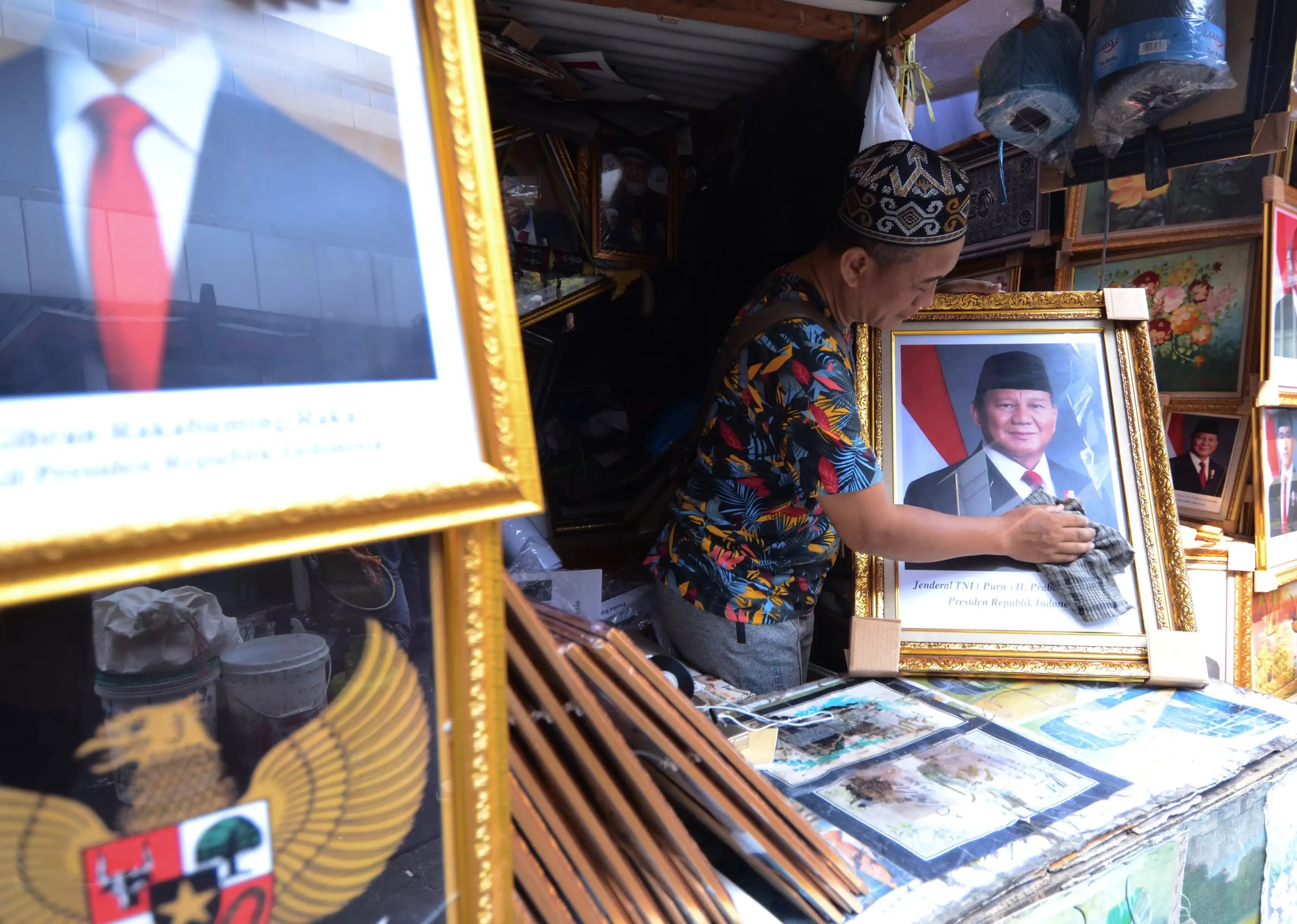 Pedagang membersihkan kaca foto presiden Prabowo Subianto (Foto: Dok MI/Donavita)