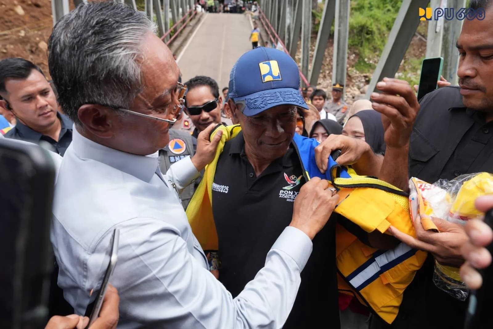 Menteri PU Kenakan Rompi Kuning dan Topi PU Kepada Penginisiasi Pembangunan Jembatan Enang-Enang
