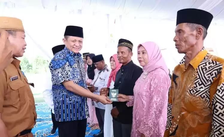 Foto Bupati OKU Timur Lanosin Hamzah menyerahkan buku nikah