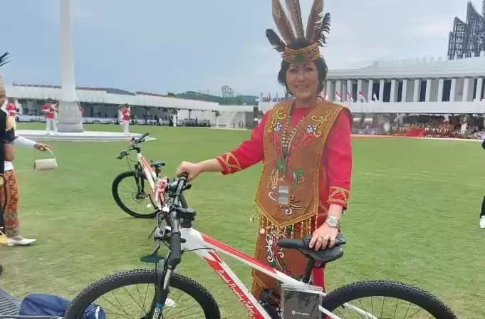 Foto Salah satu peraih busana adat terbaik mendapatkan hadian Sepeda