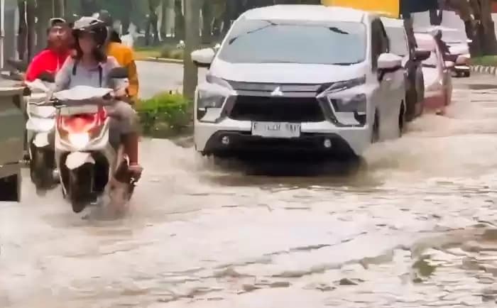 Foto Sejumlah Kendaraan Melintasi Jalan Banjir