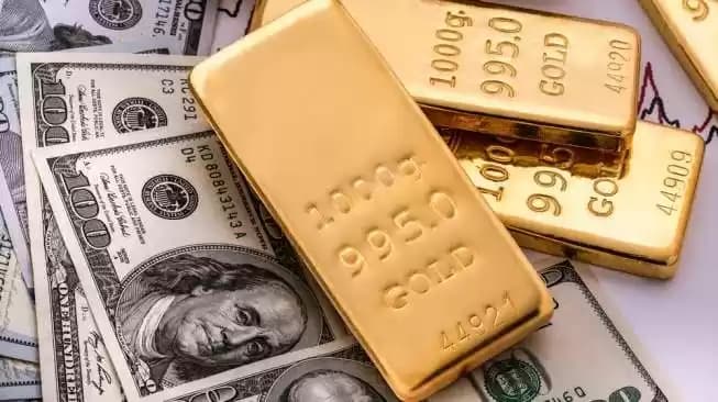 Ilustrasi - Emas batangan pada uang kertas 100 dolar AS (Foto: Shutterstock)