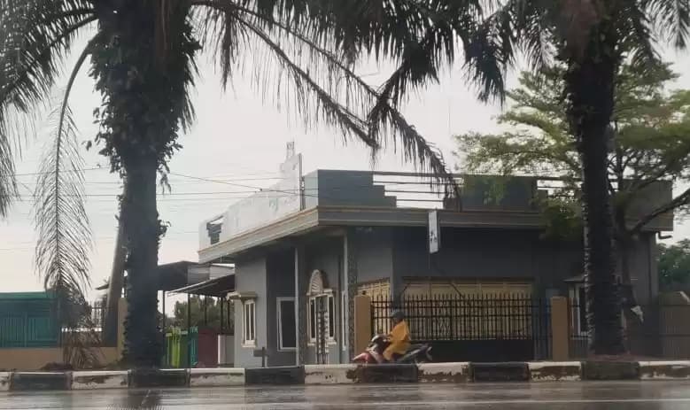 Pengendara motor mengenakan jas hujan di Kota Palembang