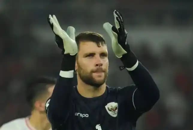Penjaga gawang Timnas Indonesia Maarten Paes merespon nyanyian suporter
