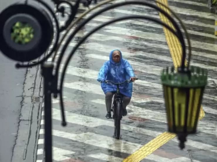 Pesepeda gunakan jas hujan