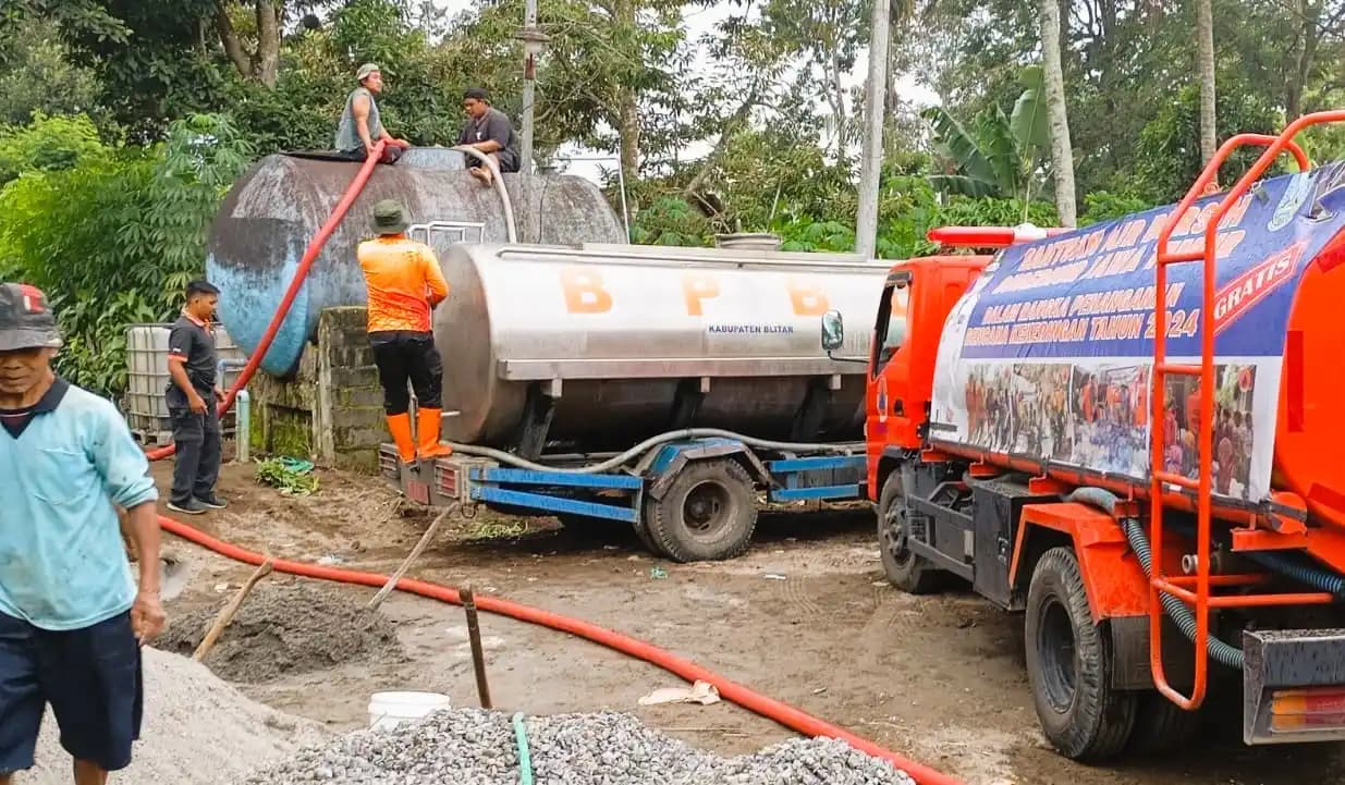 Petugas BPBD Kabupaten Blitar saat menyalurkan air bersih di Kampung Baru, Desa Karangrejo, Kecamatan Garum