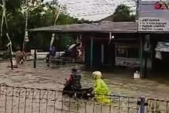 Seorang anggota TNI membantu warga mendorong sepeda motor yang mogok di jalan tergenang banjir d Grobogan. (Foto: ANTARA)
