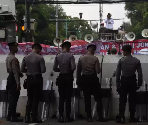 Polisi mengawasi aksi demonstrasi dari balik barikade di depan Gedung KPU, Jakarta, Senin (18/3/2024). [Foto: ANTARA]