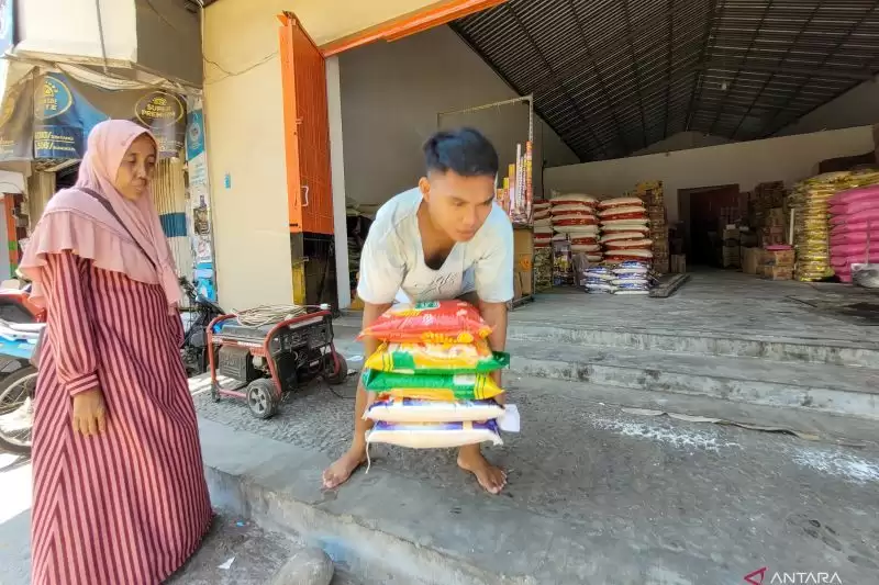 Seorang pekerja melayani warga membeli beras di salah satu distributor/toko beras di Kecamatan Besuki, Situbondo. (Foto: Antara)