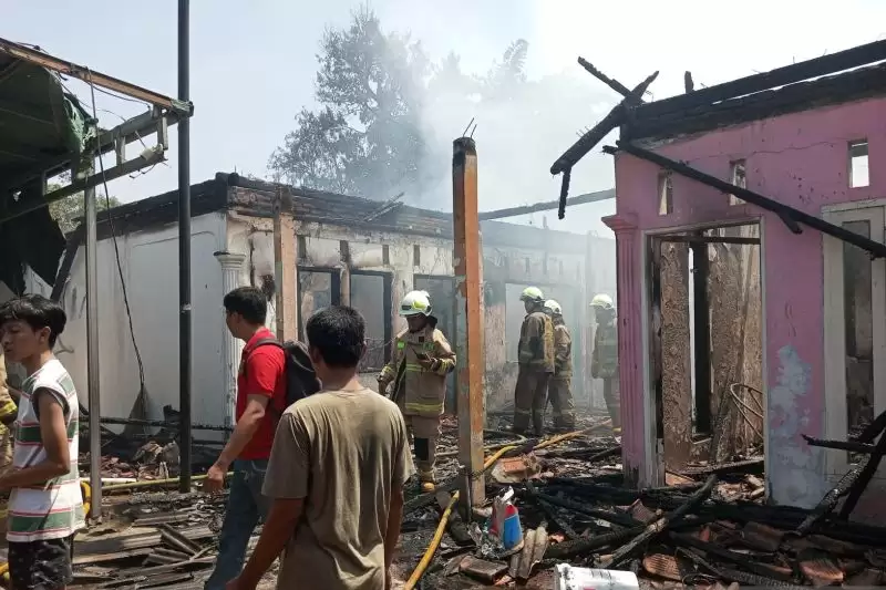 Petugas Sudin Gulkarmat Jakarta Timur tengah memadamkan api yang membakar delapan rumah kontrakan di Pondok Kelapa, Jakarta Timur, Rabu (20/12). [Foto: ANTARA]