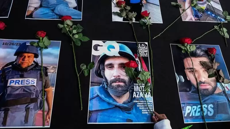 Warga menaruh bunga mawar di atas sejumlah foto jurnalis peliput konflik Israel di Gaza, Palestina pada aksi damai di Solo, Jawa Tengah [Foto: Antara]