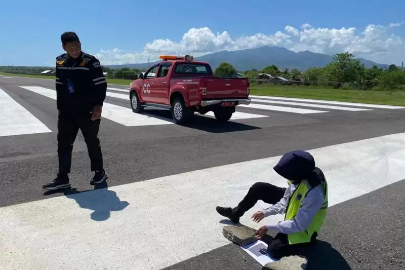 Petugas melakukan aktivitas pengujian abu vulkanik dengan paper test di landasan pacu Bandara Frans Seda Maumere, Sikka, NTT, Selasa (2/1). (Foto: ANTARA)