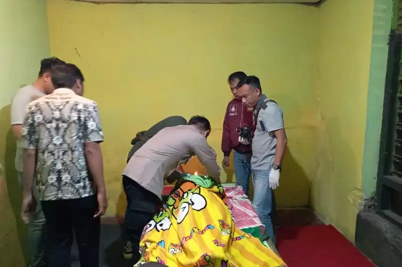 Polisi memeriksa jenazah korban, yang ditemukan meninggal dunia di depan kamar mandi rumah kekasihnya di Pare, Kabupaten Kediri, Jawa Timur. [Foto: ANTARA]