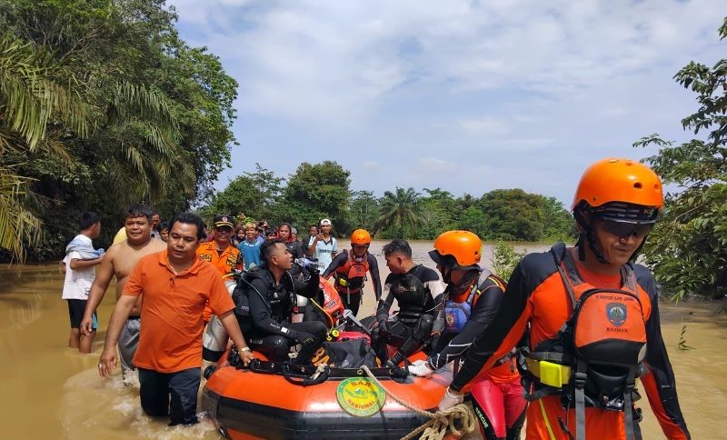 Tim SAR mengevakuasi seorang warga Kabupaten Batanghari yang tenggelam terseret arus sungai yang meluap akibat banjir di Provinsi Jambi semakin medusa. (Foto: ANTARA)