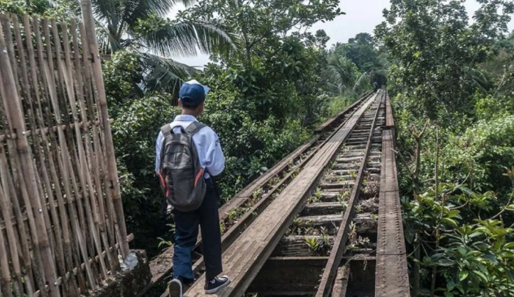 Seorang pelajar berjalan di jalur kereta api Rangkasbitung-Labuan di Saketi, Pandeglang (Foto : Antara )