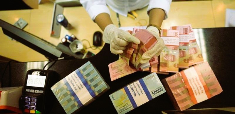Ilustrasi - Petugas menghitung uang dolar AS dan uang rupiah di salah satu kantor cabang PT Bank Negara Indonesia (Persero) Tbk. (Foto: ANTARA)