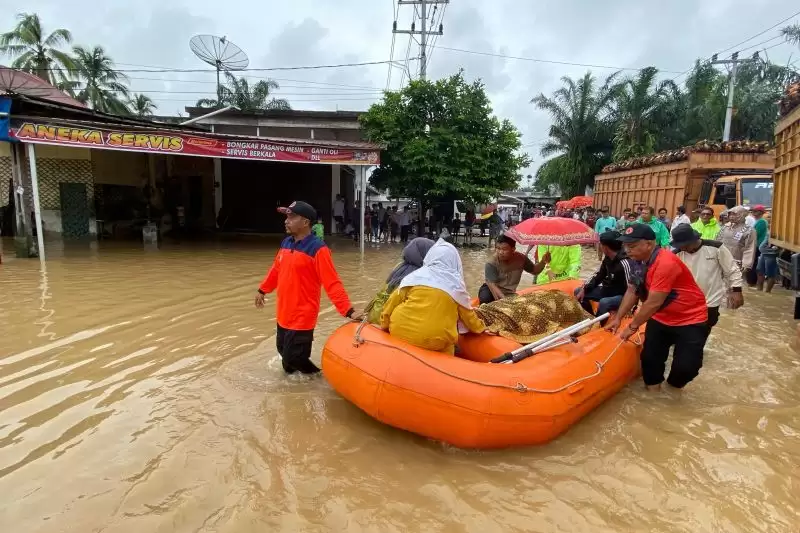 BPBD Pasaman Barat saat mengevakuasi jenazah, menggunakan perahu karet melintasi genangan banjir di Batang Pasaman, Kecamatan Pasaman, Jumat (8/3/2024). [Foto: BPBD Pasaman Barat).