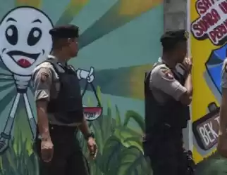 Polisi berjalan di depan mural kampanye Pemilu 2019 di Banda Aceh, 17 Maret 2019.