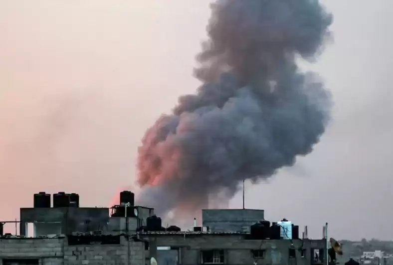 Asap mengepul di atas gedung-gedung selama serangan udara Israel di kota Rafah, Jalur Gaza selatan pada 11 Mei 2023 (Foto: AFP)
                                    class=