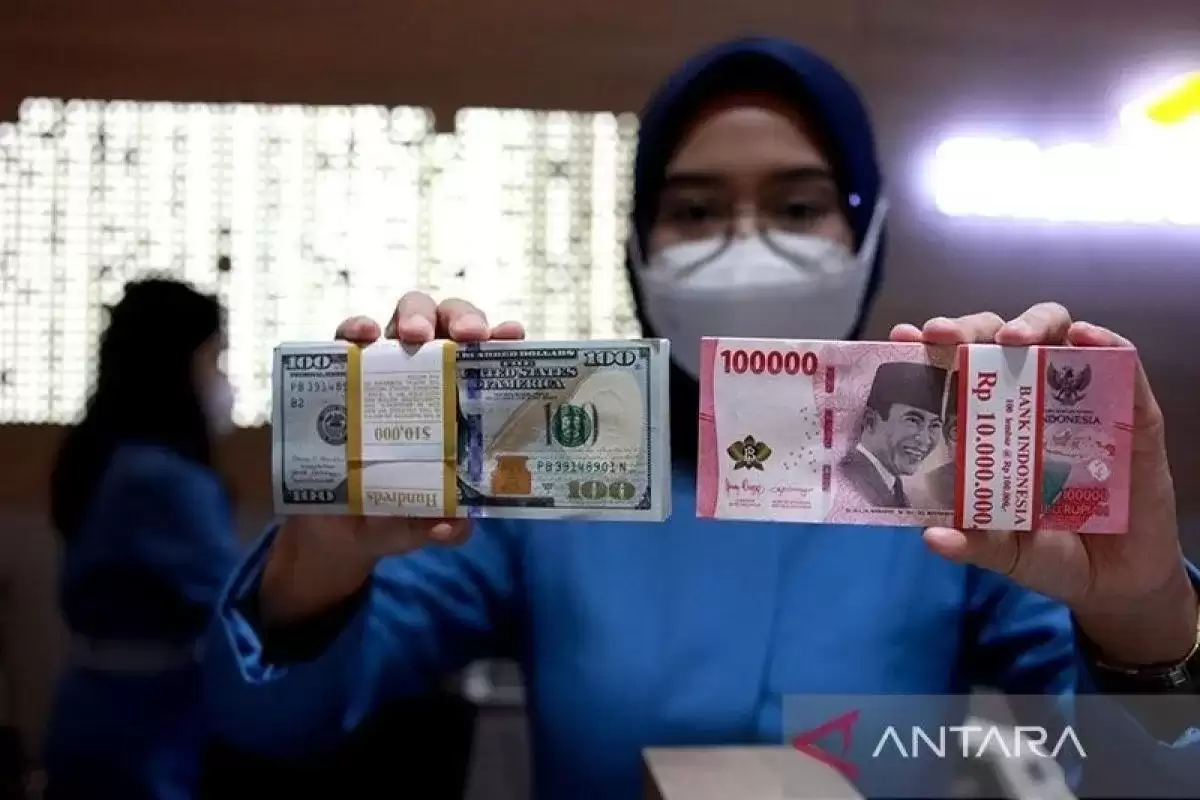 Ilustrasi - Petugas menunjukkan uang dolar AS dan uang rupiah di salah satu kantor cabang Bank Mandiri di Jakarta. (Foto: ANTARA)