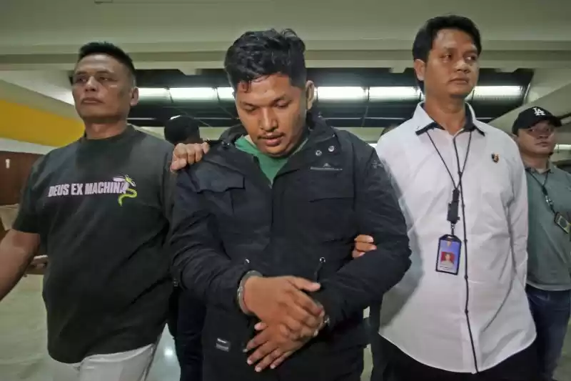 Petugas kepolisian menggiring tersangka berinisial S (tengah) yang diduga sebagai bandar besar narkoba setibanya dari Medan di Terminal 2 Bandara Soekarno Hatta, Tangerang, Banten, Senin (27/5/2024). [Foto: Antara]