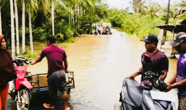Warga terjebak banjir saat melintasi jalan di kawasan Desa Pasi Ara Aceh Barat (Foto: Antara)