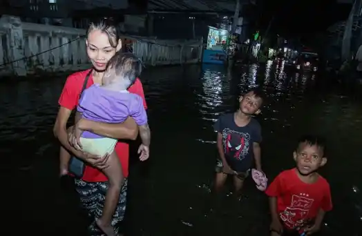 Sejumlah warga berjalan saat banjir rob di kawasan Muara Angke, Jakarta, Senin (18/11/2024). [Foto: Antara]
