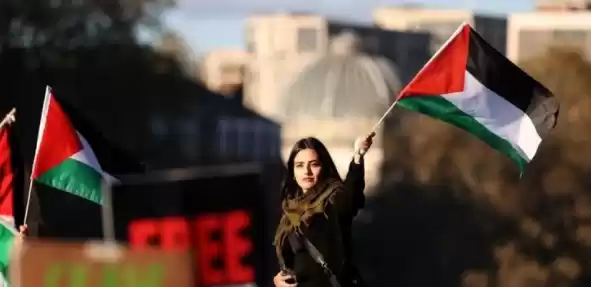 Seorang wanita mengibarkan bendera Palestina. (Foto: ANTARA)
                                    class=