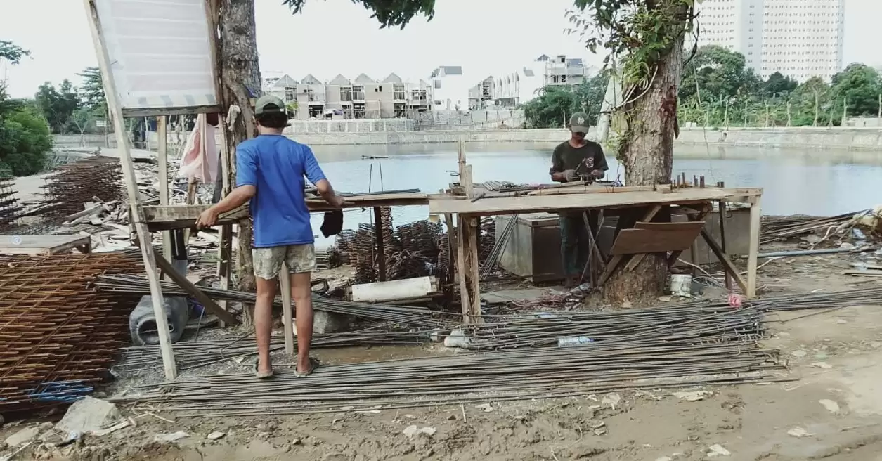 Dua pekerja sedang merakit besi kerangka bangunan suatu proyek (Foto: Dok MI)