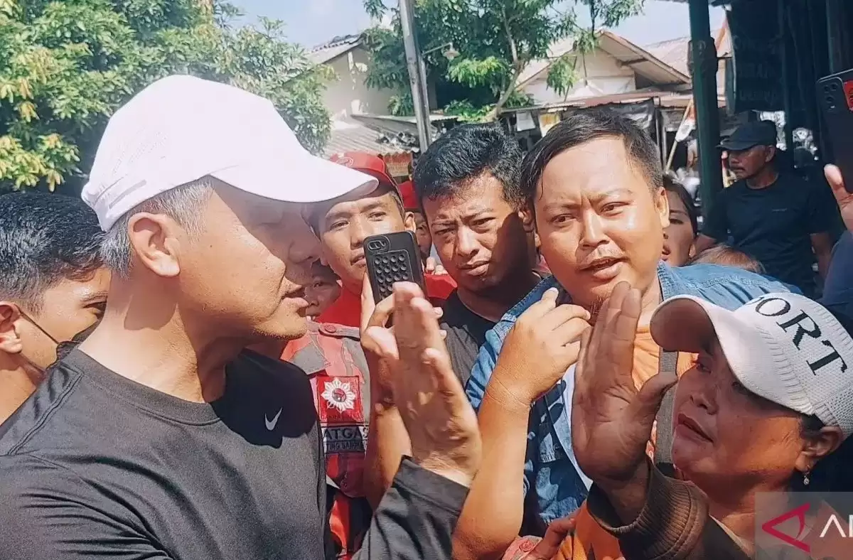 Calon presiden nomor urut 3 Ganjar Pranowo (kiri) mengajak tos pedagang Pasar Klithikan Notoharjo Sri Mulyani (kanan) di Surakarta, Jawa Tengah (Foto: Antara)