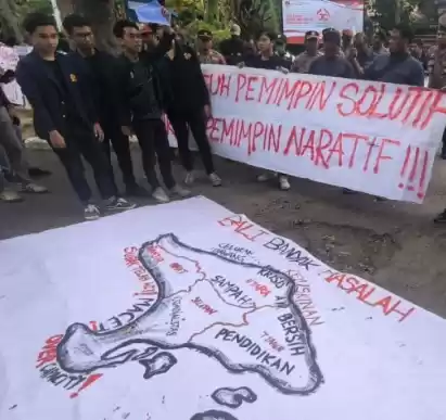 Massa aksi memasang spanduk permasalahan Bali di depan kantor KPU Bali di Denpasar, Selasa (27/8/2024). [Foto: ANTARA]