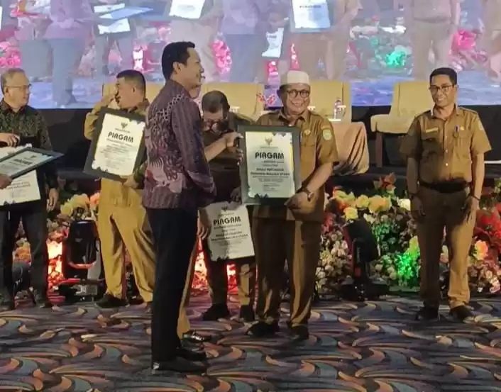 epala Bappeda Maluku Utara, M. Sarmin S. Adam mewakili Penjabat Gubernur Samsuddin Abdul Kadir menyerahkan piagam penghargaan kepada Plt Kepala Dinas Pertanian Muhtar Husen (Foto: Istimewa)