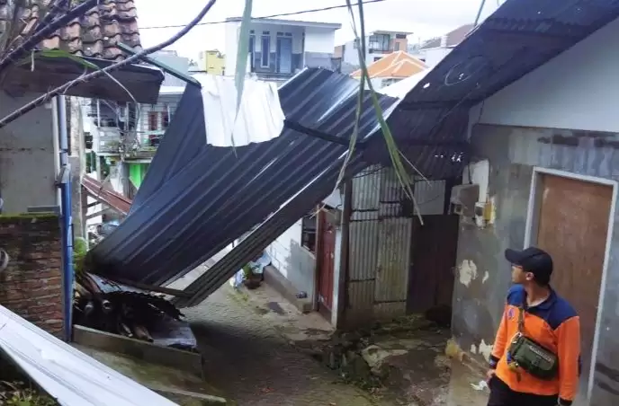 Personel BPBD Kota Batu melihat kondisi salah satu rumah yang mengalami kerusakan akibat dampak cuaca ekstrem di Kota Batu, Jawa Timur, Selasa (12/3/2024). (Foto: ANTARA)