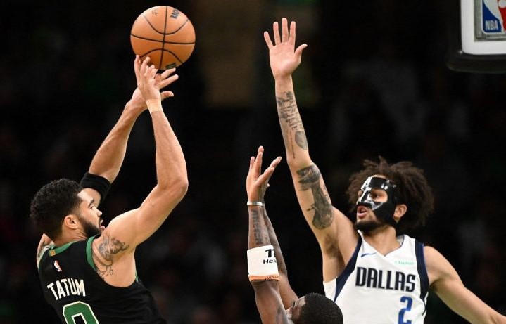 Pemain Boston Celtics Jayson Tatum  berupaya melempar bola melewati kawalan pemain Dallas Mavericks Kyrie Irving dan Dereck Lively II dalam laga di TD Garden Boston, Massachusetts. (Foto: ANTARA)