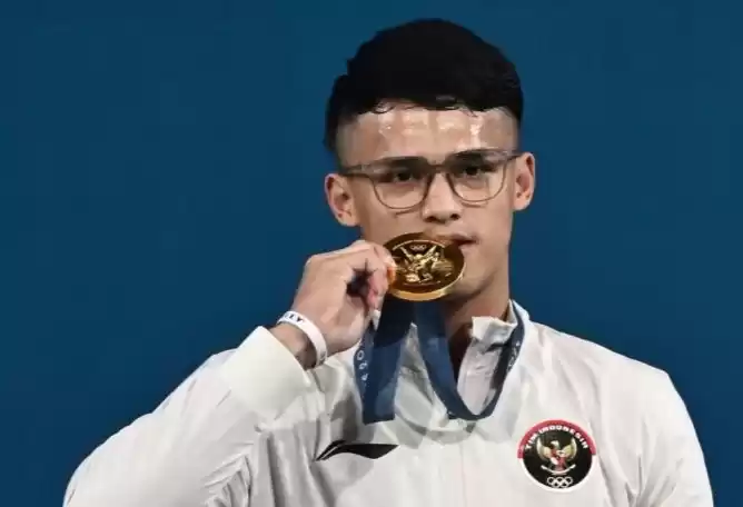 Lifter Indonesia Rizki Juniansyah berpose dengan medali emasnya.(Foto: Antara)