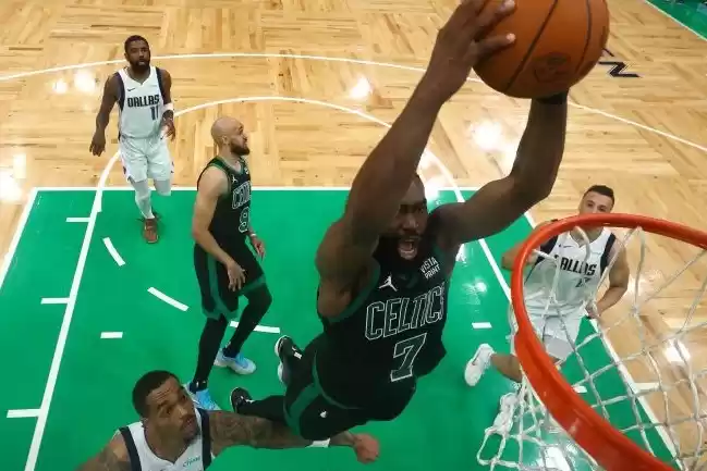 Pebasket Boston Celtics Jaylen Brown #7 melakukan dunk di depan pebasket Dallas Mavericks P.J. Washington. (Foto: Antara)