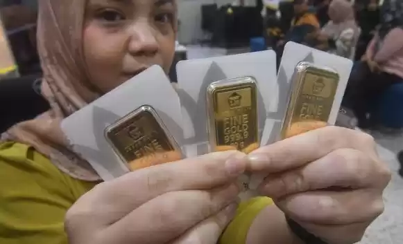 Petugas menunjukkan emas batangan di Butik Emas Logam Muli. (Foto: Antara)