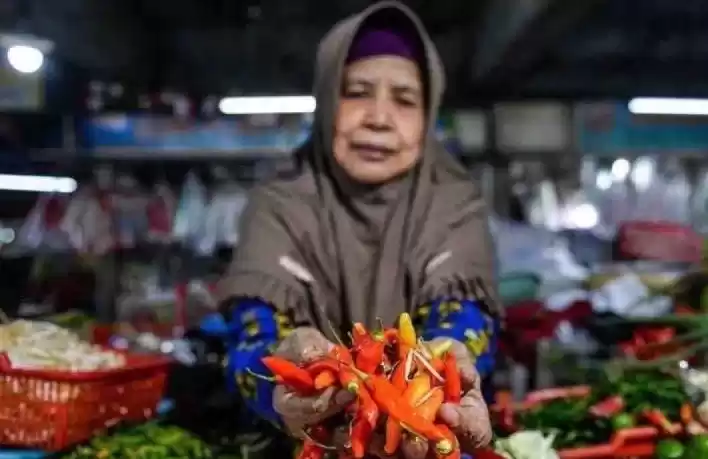 Pedagang menunjukkan cabai rawit yang dijual di Pasar. (Foto: Antara)