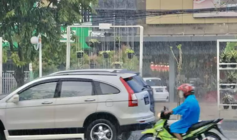 Pengendara melintas di tengah guyuran hujan deras. (Foto: Antara)