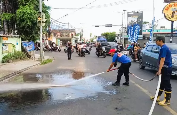 Petugas membersihkan bekas kecelakaan bus pariwisata yang melindas seorang pengguna jalan hingga tewas. (Foto: Antara)