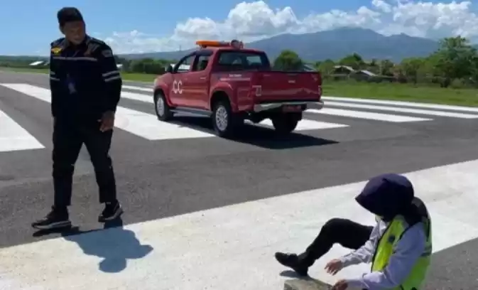 Petugas melakukan aktivitas pengujian abu vulkanik dengan paper test di landasan pacu Bandara Frans Seda Maumere, Sikka, NTT. (Foto: Antara)