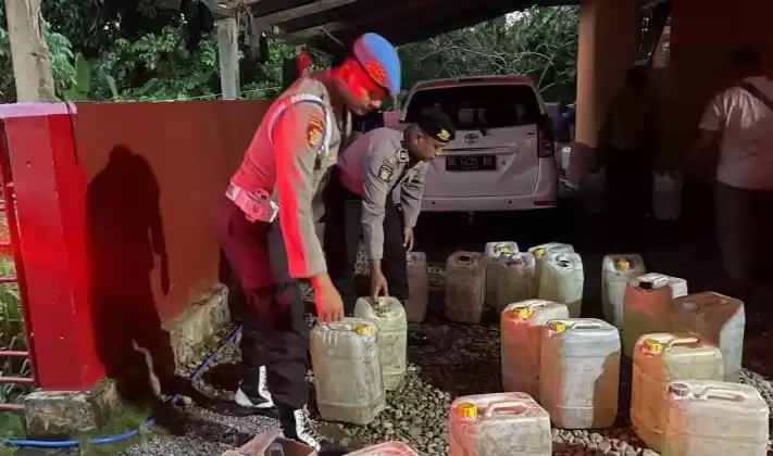 Polisi saat mengamankan ribuan liter miras di salah seorang warga Desa Alang, Maluku Tengah. (Foto: Antara)