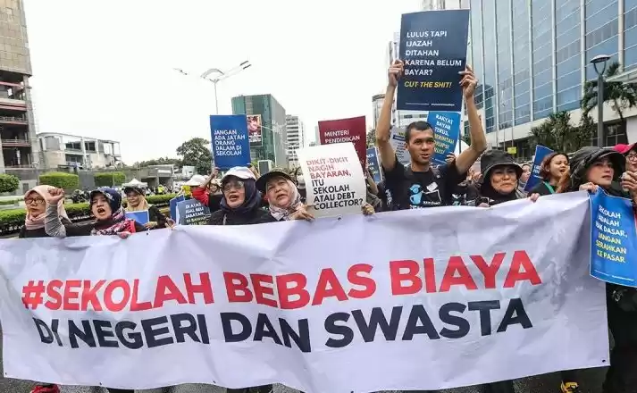 Sejumlah aktivis dari Jaringan Pemantau Pendidikan Indonesia berjalan sambil membentangkan spanduk. (Foto: Antara)