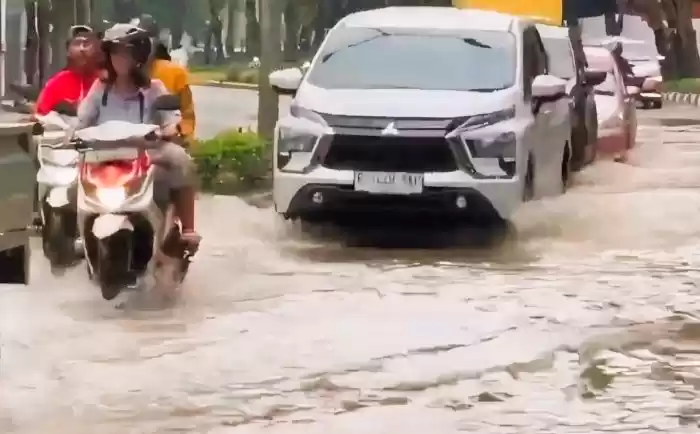 Kendaraan tengah melintas di jalan yang terendam banjir. (Foto: Antara)