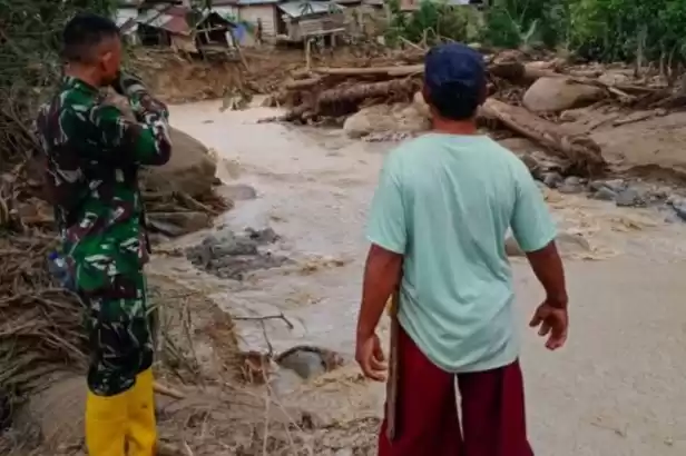 Warga Desa Tuva Kabupaten Sigi bersama Babinsa setempat saat mengecek lokasi banjir dan longsor. (Foto: Antara)