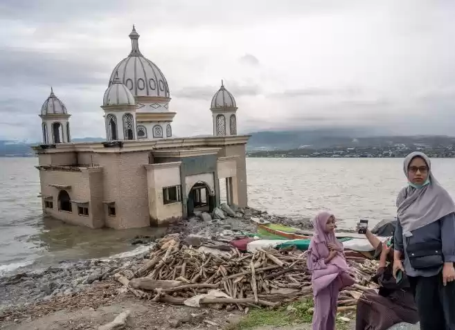 Ilustrasi Tsunami - Pengunjung berada di dekat masjid terapung Arqam Baburrahman yang amblas ke laut. (Foto: Antara)
