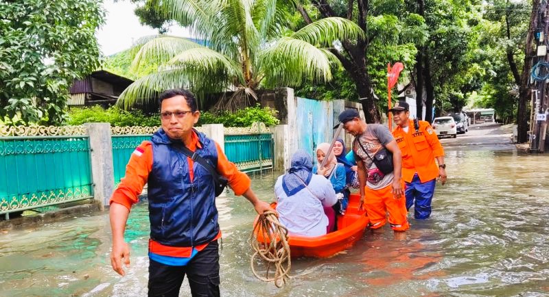 Petugas Badan Penanggulangan Bencana Daerah (BPBD) DKI Jakarta mengantar warga menggunakan perahu karet menuju TPS Jakarta Barat, Rabu (14/2). (Foto: ANTARA)