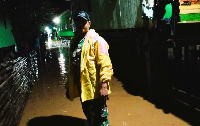 Seorang personil TNI saat mengecek keadaan warga dengan melewati genangan air banjir, Nusa Tenggara Barat (NTB), Senin (26/2/2024). (Foto: ANTARA)