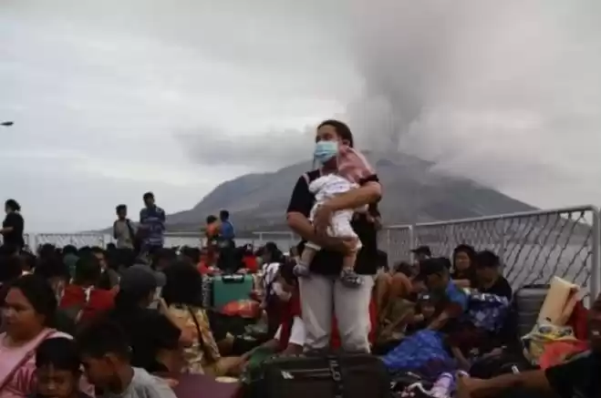 Seorang warga mengendong anaknya berada di atas geladak KRI Kakap-811 saat dievakuasi di Pelabuhan. (Foto Antara)